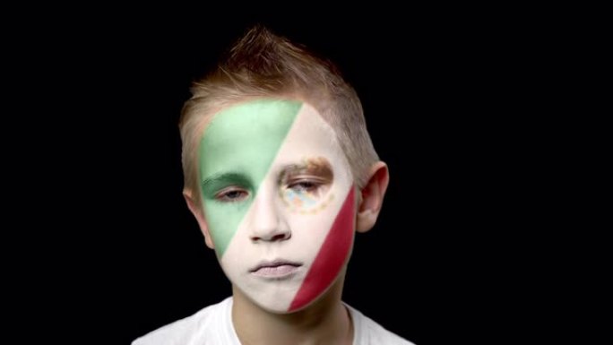 墨西哥足球队的伤心球迷。脸上涂着民族色彩的孩子。