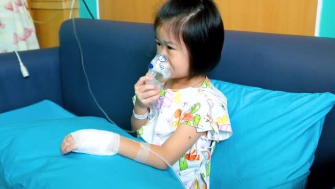 可爱的亚洲孩子拿着口罩蒸气吸入器治疗哮喘。