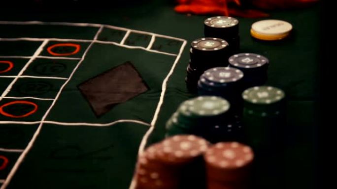 带有红色扑克筹码的扑克桌在许多彩色筹码的赌场中转动