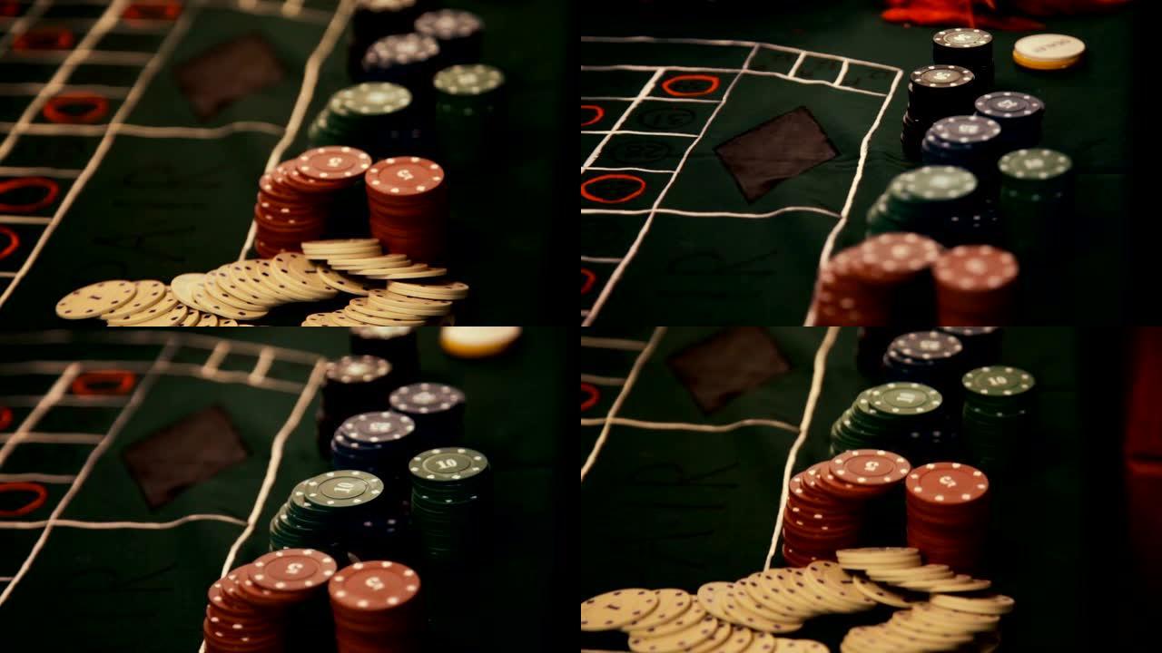 带有红色扑克筹码的扑克桌在许多彩色筹码的赌场中转动