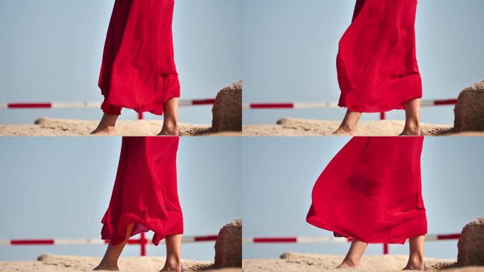 红色连衣裙随风飞翔，赤脚女孩站在岩石上，超级慢动作，浪漫美丽的概念。