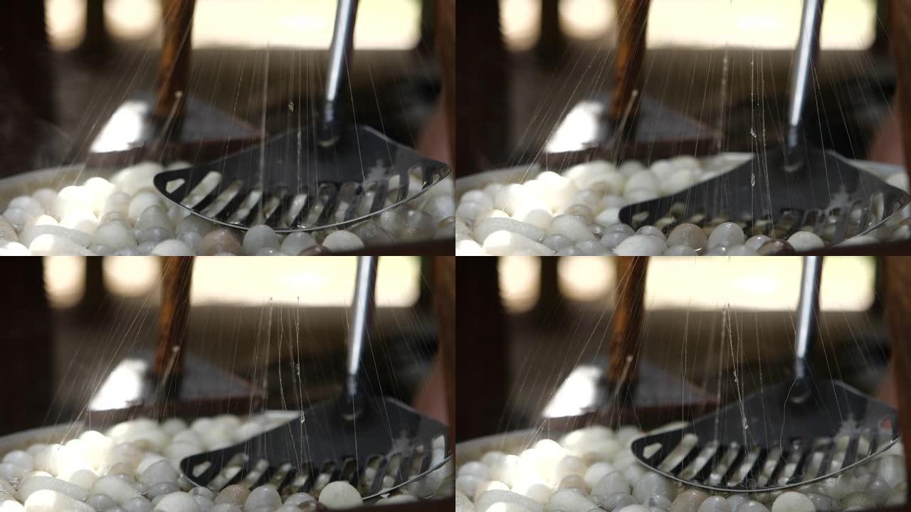 蚕茧在丝绸生产工匠中，近距离用蒸汽慢动作的蚕茧
