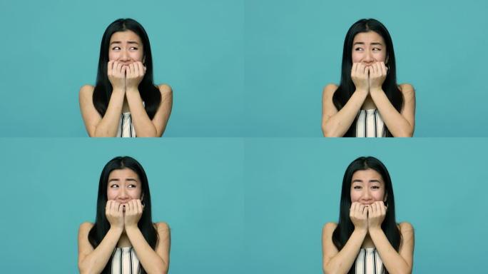 焦虑障碍。害怕担心的亚洲女人，长长的黑发咬着指甲，手指，看上去很害怕和惊慌失措