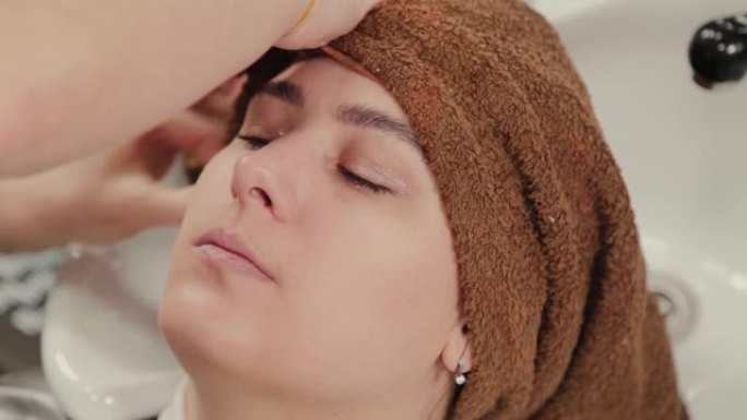 专业美发师女人用毛巾给客户擦头发