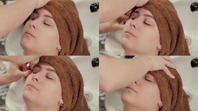 专业美发师女人用毛巾给客户擦头发