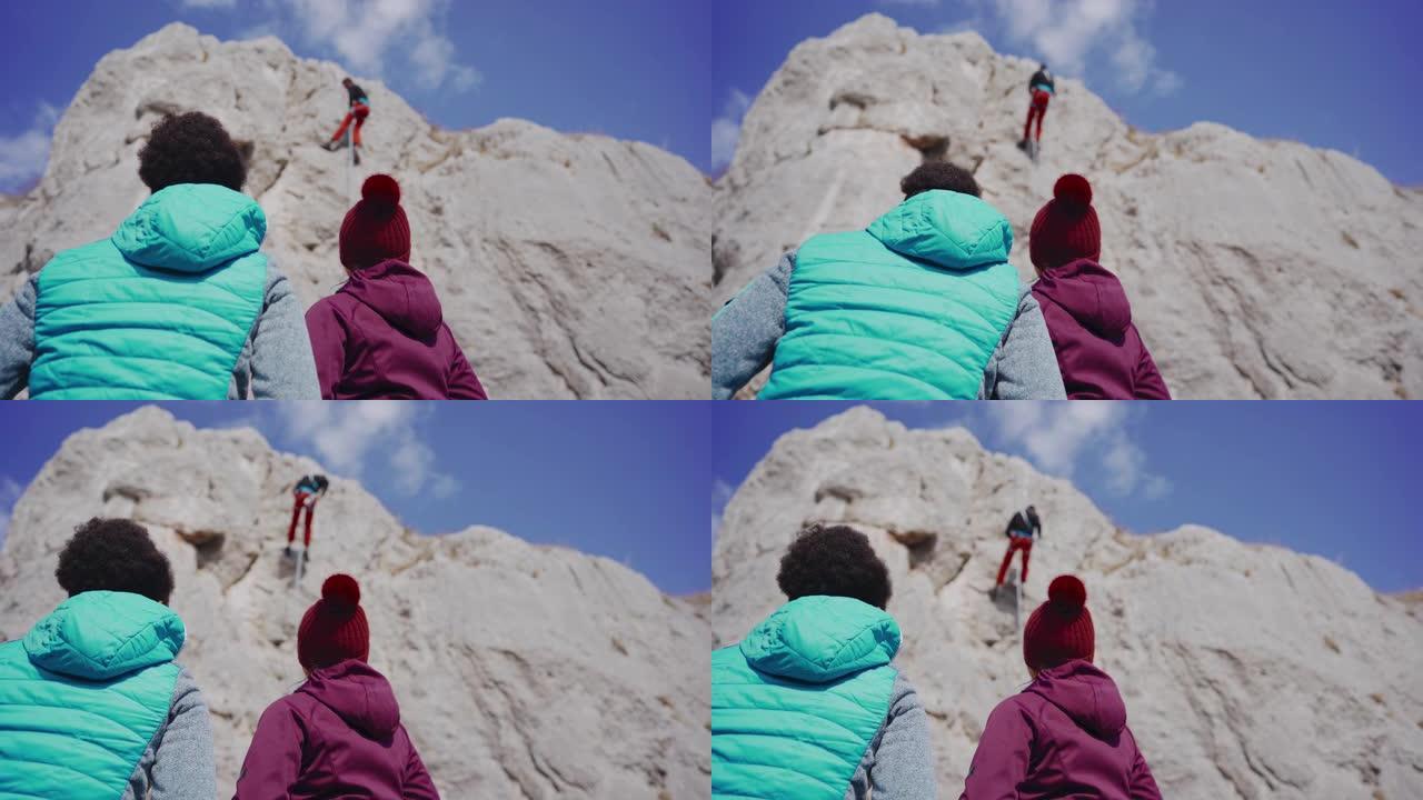 两个女人看着男人从悬崖上被掩盖
