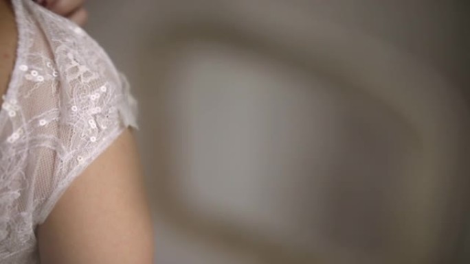 年轻女子站在房间里，在婚礼前调整婚纱