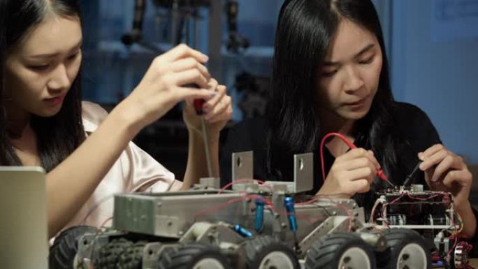 亚洲女工程师在实验室组装和测试机器人手臂反应。建筑师设计电路同步技术和协作开发机器人。
