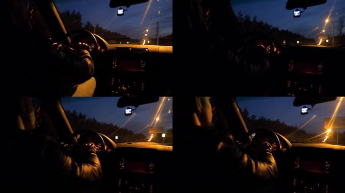 男性驾驶员在夜间手握方向盘并在高速公路上自动驾驶。晚上那家伙开现代汽车。年轻人在空旷的道路上开着他的