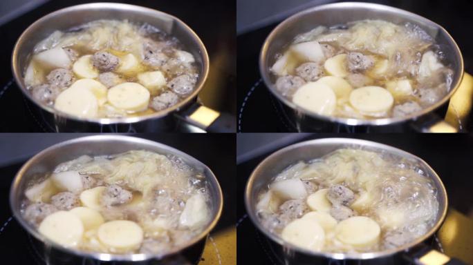 在炉子上的火锅里煮沸的鸡蛋豆腐和粉丝汤。健康的概念。