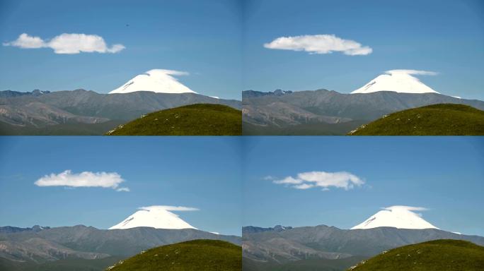 埃尔布鲁士山东坡的延时景观。在夏天阳光明媚的日子里，在雪山上云层的湛蓝天空中形成。云形成天气变化概念