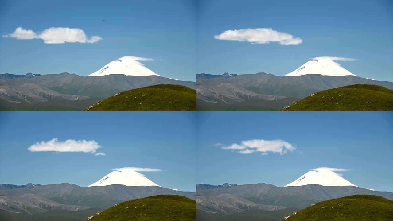 埃尔布鲁士山东坡的延时景观。在夏天阳光明媚的日子里，在雪山上云层的湛蓝天空中形成。云形成天气变化概念
