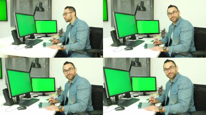 英俊的youn man图形艺术家在办公室工作，使用电脑和图形平板电脑4k 50fps镜头chroma