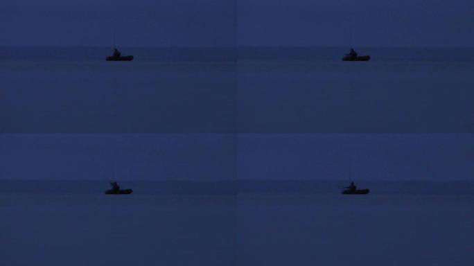 晚上在水面上乘船的渔夫的剪影