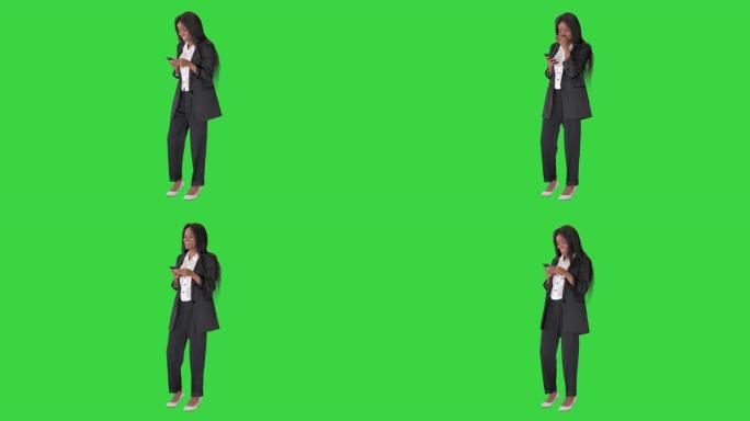 快乐的非洲裔美国年轻女商人拿着智能手机社交媒体应用程序，在绿屏上大笑，色键