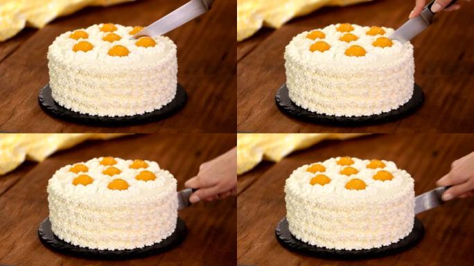 Female hands cutting homemade cream cake with peac
