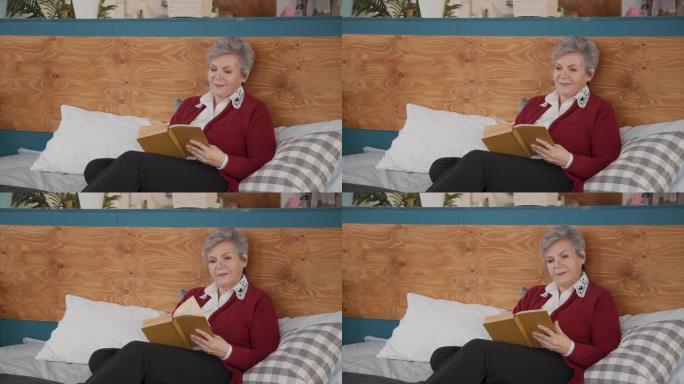 退休的女性养老金领取者在卧室里阅读小说