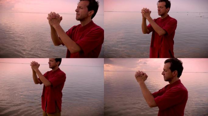 一名男子站在水中祈祷时闭上眼睛的手持镜头