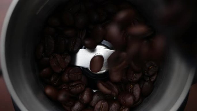 咖啡豆在慢动作中落入咖啡研磨机。咖啡种子的特写。