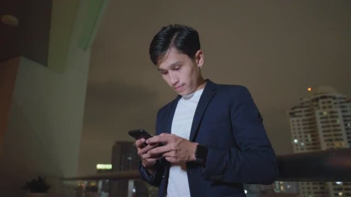亚洲男子在午夜街头城市使用智能手机