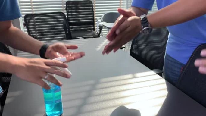 将酒精涂抹在清洁的手上，以保护新型冠状病毒肺炎病毒传播到办公室的员工
