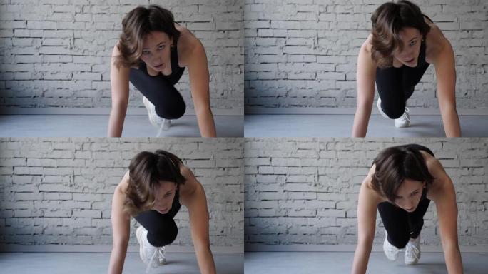 运动美女做跑步木板作为她的交叉健身，健美健身房训练程序的一部分。前视图特写