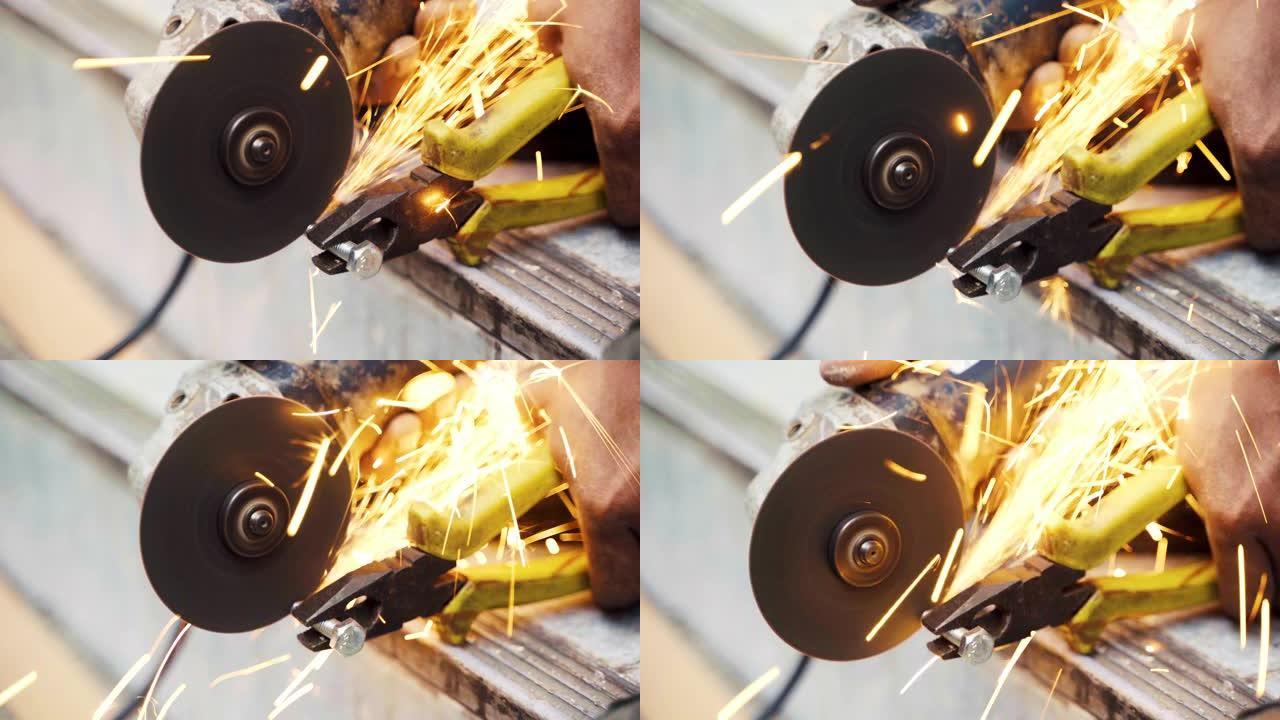 手工工人用电动磨床锯磨削金属螺钉的特写。