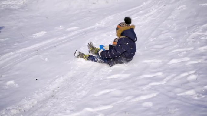 雪地滑梯上的男孩。