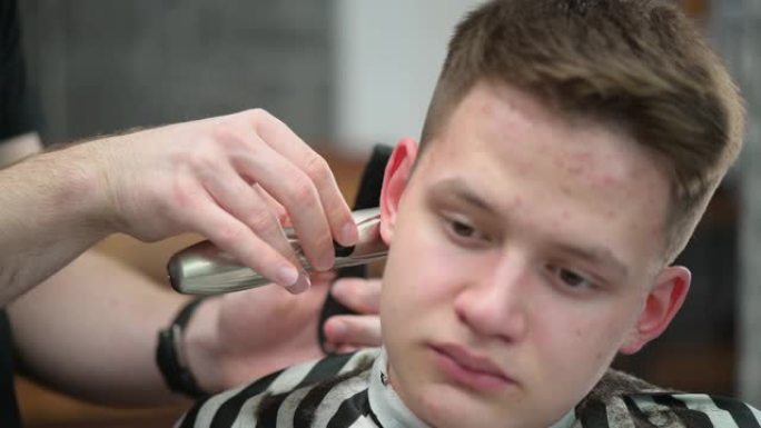 理发店里年轻人的发型。用剪刀剪发大师的特写