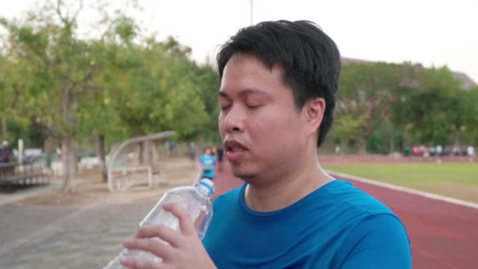 男子跑步后喝水。男子跑步后喝水