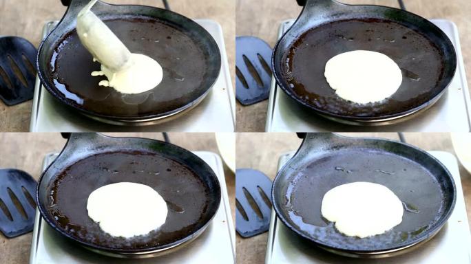 Pouring dough for a pocake on a hot pan
