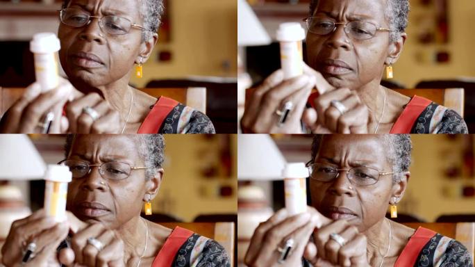 非裔美国高级妇女试图阅读她手中的药瓶标签