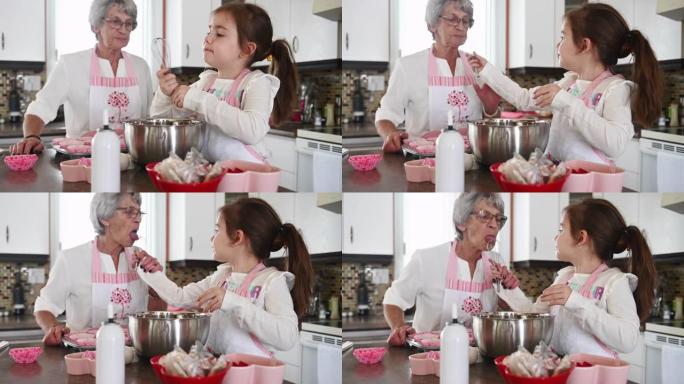 小女孩和祖母一起烹饪情人节松饼