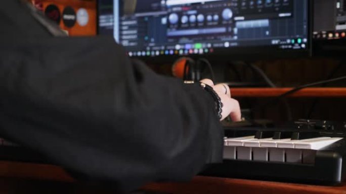 年轻艺术家在家庭录音棚用电子钢琴键盘创作歌曲。在音乐工作室用钢琴演奏。音响工程师正在制作一首歌。