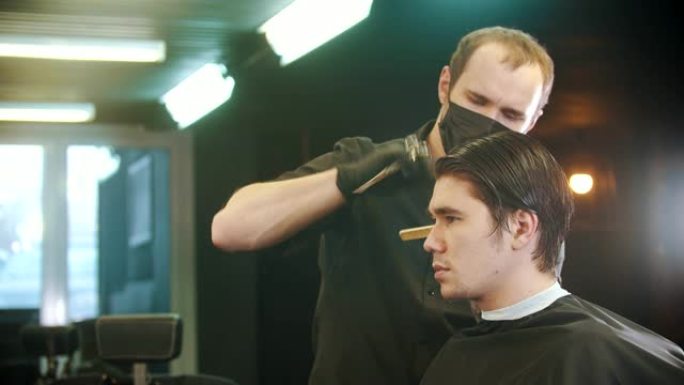 理发师将年轻客户的湿头发部分刷掉以进行切割