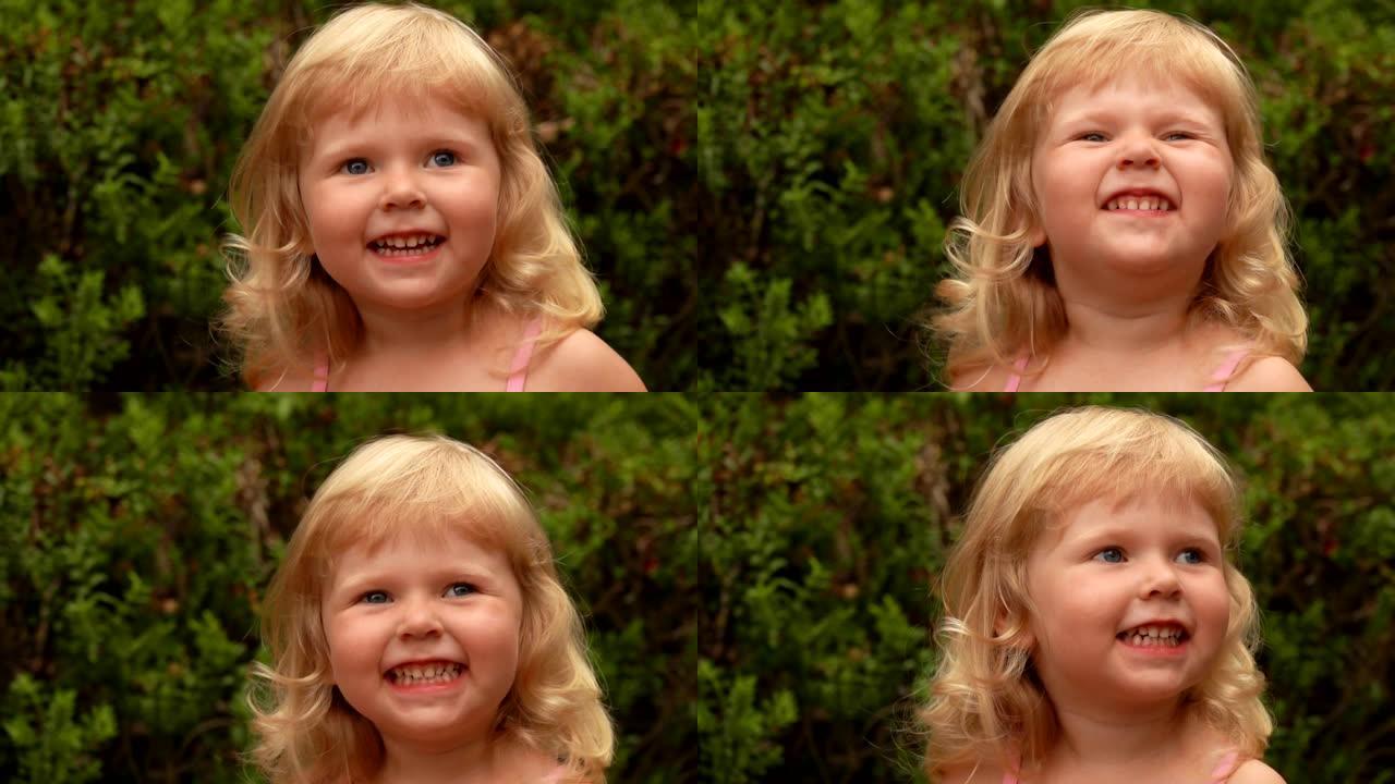 一个美丽的金发小女孩在户外微笑和大笑的肖像