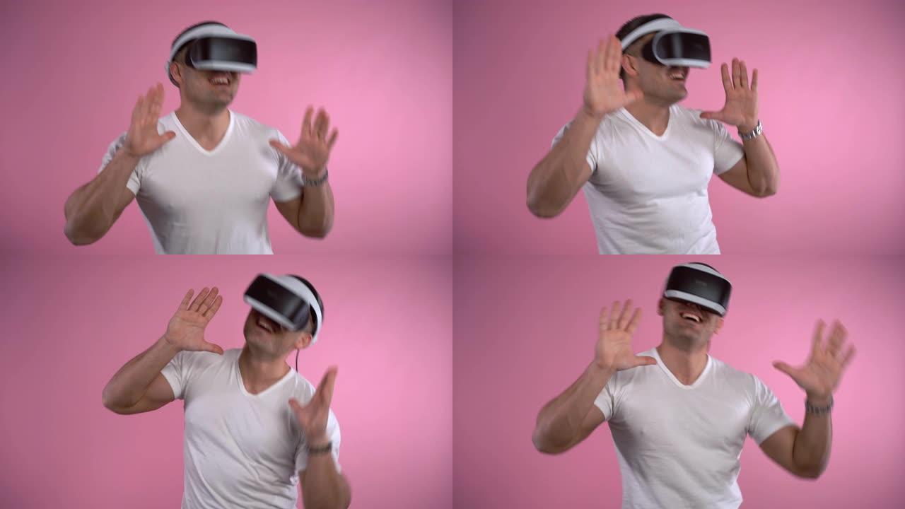 微笑的人测试虚拟现实耳机，双手在粉色背景上打手势跳舞。工程创新，增强现实中的互动游戏。VR眼镜和娱乐