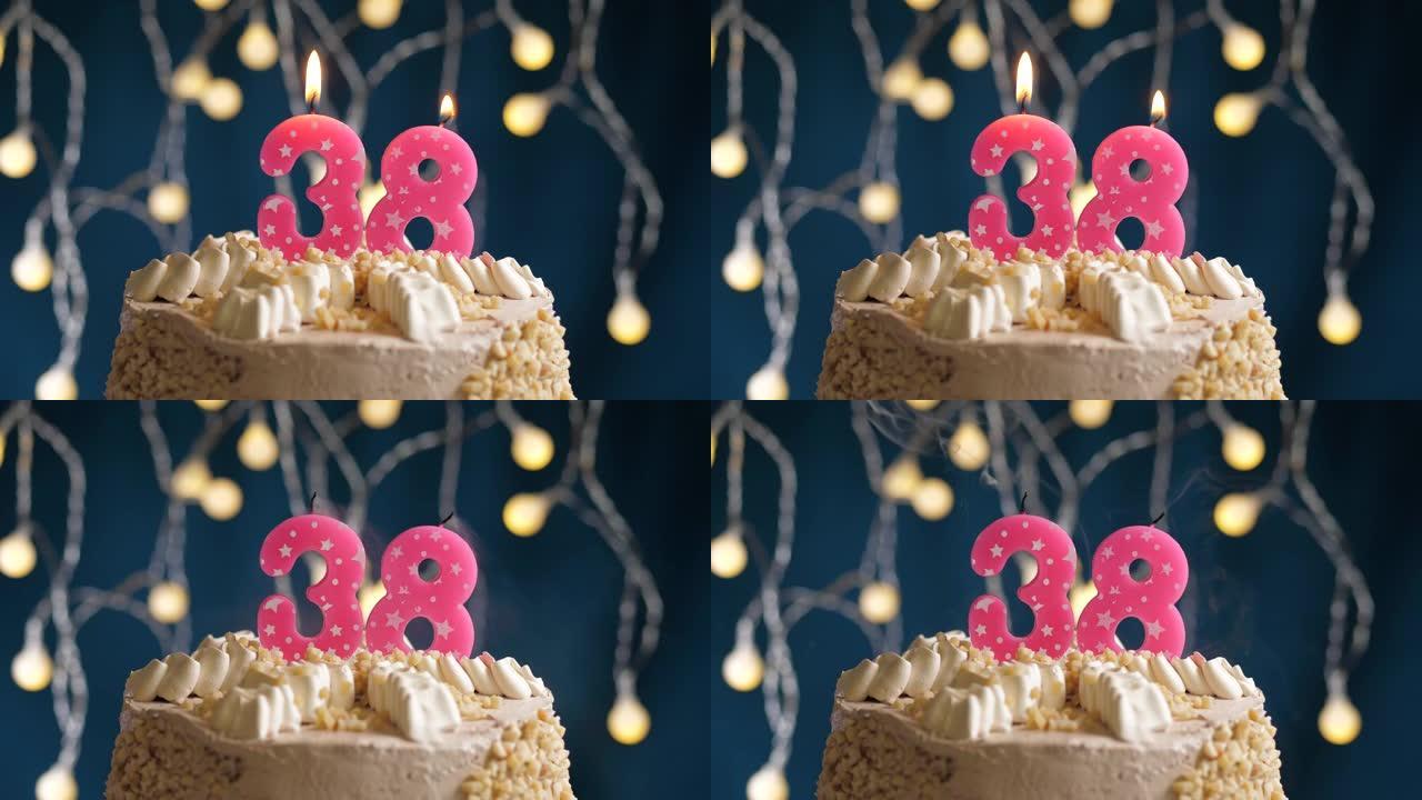 蓝色背景上有38号粉色蜡烛的生日蛋糕。蜡烛吹灭了。慢动作和特写视图