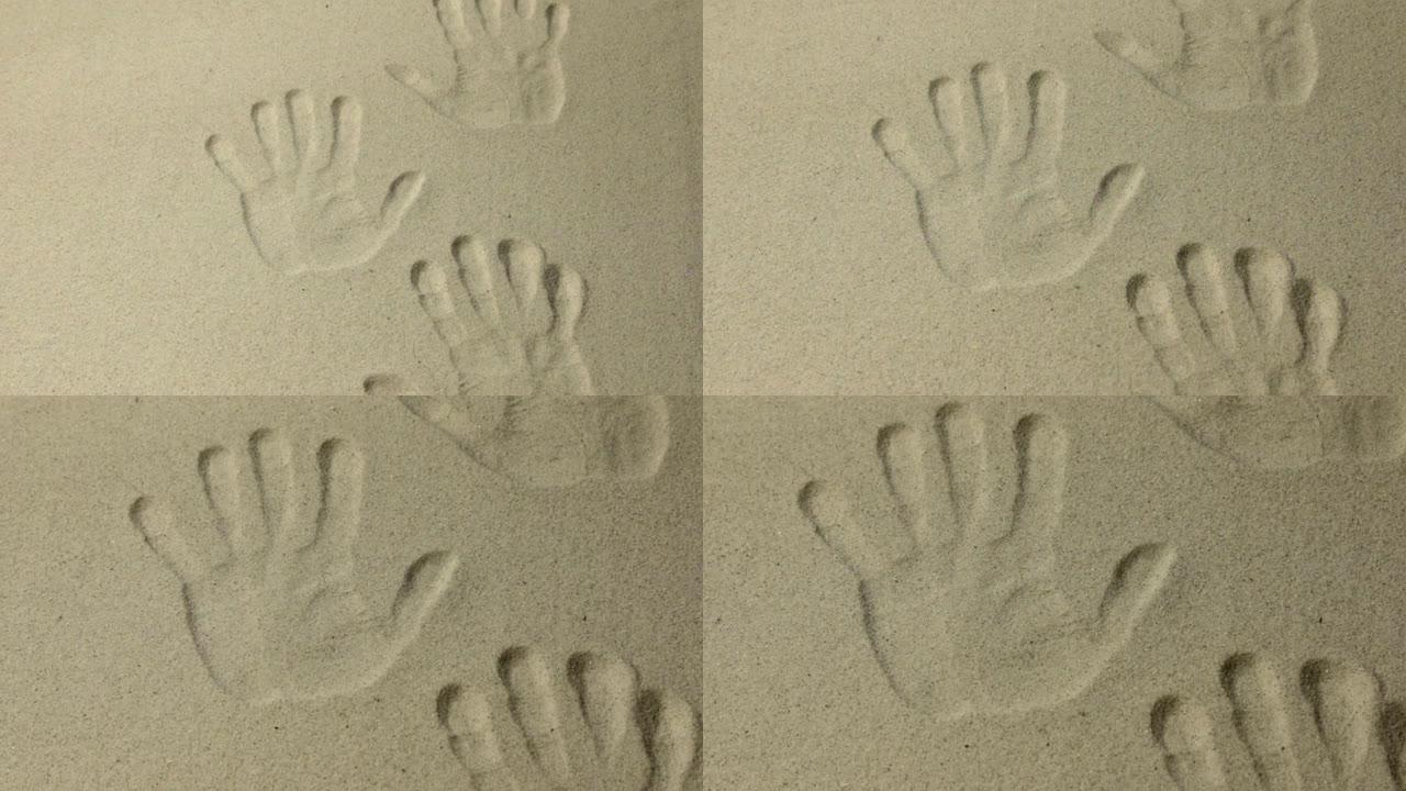 许多人类双手在沙滩上的印记，作为背景，缩放。