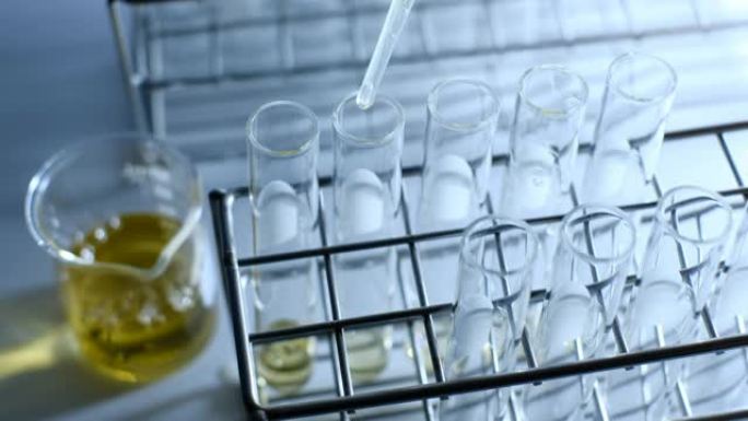 科学家在实验室实验中将化学溶液滴入试管中。化学和石油概念
