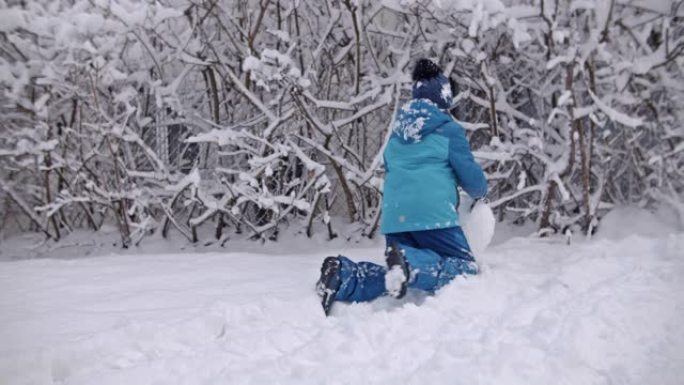 小男孩在冬天堆雪人