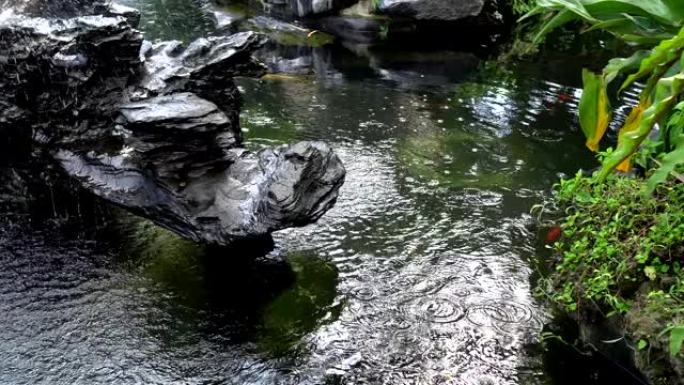 喷泉里有黑色的石头。园林绿化是中国式的。
