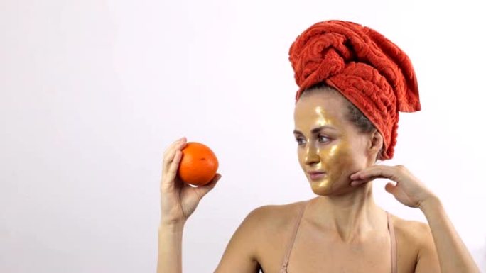 与橙色水果相比，一个年轻女孩的脸上露出金色的面具