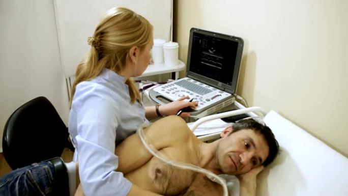 女医生使用超声波设备检查病人的心脏。高清