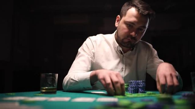 男子在暗室扑克游戏中堆积赌博筹码