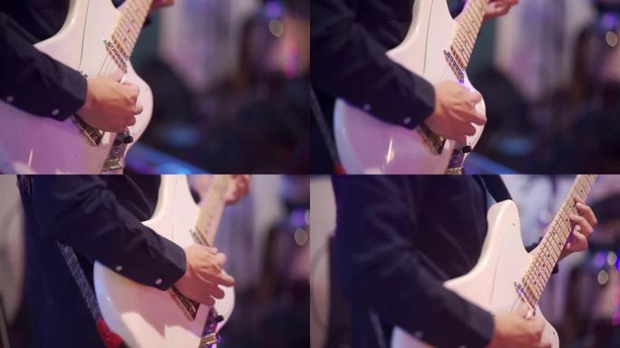 男子在舞台上演奏白色吉他