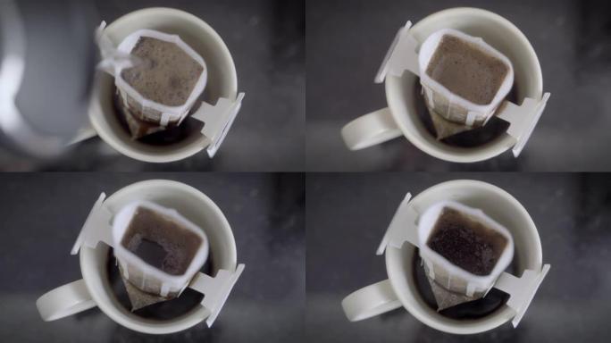 特写镜头将热的新鲜浓缩咖啡滴入黑色背景的白色杯子过滤器中。