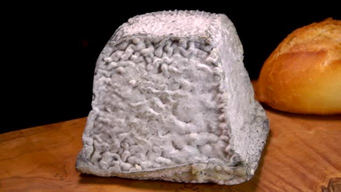 金字塔瓦伦凯奶酪放在长棍面包旁边的木板上