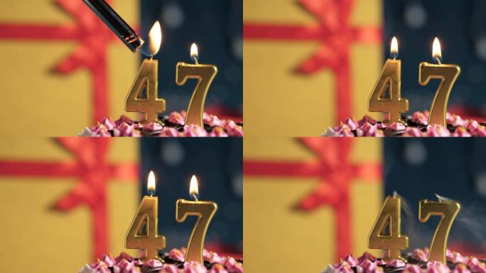生日蛋糕编号47点灯燃烧的金色蜡烛，蓝色背景礼物黄色盒子用红丝带绑起来。特写和慢动作