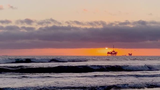 从亨廷顿海滩 (Huntington Beach) 可以欣赏到海上石油钻机平台上的壮丽日落